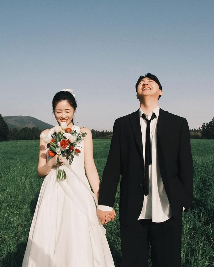 Dion and Ajeng laughing together in a meadow